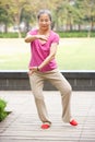 Senior Chinese Woman Doing Tai Chi In Park