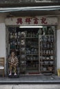 Senior Chinese woman sits by the family ceramics shop in Hong Kong.