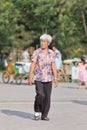 Senior Chinese woman walks in a park on a summerday, Beijing, China