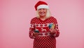 Senior Christmas grandmother woman use mobile cell phone plastic credit bank cards win calebrate wow