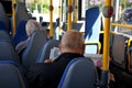 Senior citizen bus passenger reading free news papers