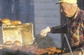 A senior citizen grilling hot dogs