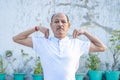 Senior Citizen or an Old Indian Man Performing Yoga Early Morning, in his Terrace in white Tshirt and Pants. Stay Home Stay Safe a Royalty Free Stock Photo