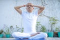 Senior Citizen or an Old Indian Man Performing Yoga Early Morning, in his Terrace in white Tshirt and Pants. Stay Home Stay Safe a Royalty Free Stock Photo