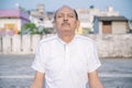 Senior Citizen or an Old Indian Man Performing Yoga Early Morning, in his Terrace in white Tshirt and Pants. Stay Home Stay Safe a Royalty Free Stock Photo