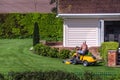 Senior citizen riding lawn mower in a garden Royalty Free Stock Photo