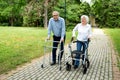 Senior citizens walking through the park with walking aid Royalty Free Stock Photo