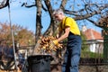 Senior collecting fallen autumn leaves in the yard Royalty Free Stock Photo