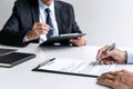 Senior committee manager reading a resume during a job interview, Employer interviewing to ask young male job seeker for