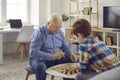 Senior concentraited man grandfather sitting and playing checkers with his grandson Royalty Free Stock Photo