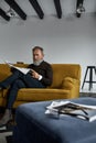 Senior concentrated man reading newspaper on sofa