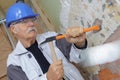 Senior construction worker with chisel and hammer