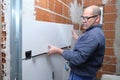 Senior constructor worker laying white ceramic tiles on the wall. Royalty Free Stock Photo