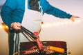 Senior cooking meat on barbecue - Chef grilling meat and serving sausages at dinner on rooftop