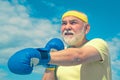 Senior cool man fighting. Best cardio workout. Senior man wearing boxing gloves. Portrait of a determined senior boxer