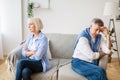 Senior couple after argument sitting on opposite sides of sofa Royalty Free Stock Photo