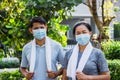 Senior couple Asian men and women are spraying each other with alcohol. People put on face masks and exercise clothes before Royalty Free Stock Photo