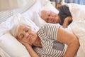 Senior couple asleep in their bed at home