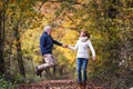 Senior couple in an autumn nature, holding hands and jumping. Royalty Free Stock Photo