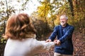 Senior couple in an autumn nature, holding hands and spinning. Royalty Free Stock Photo