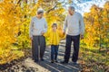 Senior couple with baby grandson in the autumn park. Great-grandmother, great-grandfather and great-grandson