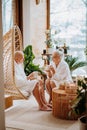 Senior couple in bathrobes enjoying time together in their living room, drinking hot tea, calm and hygge atmosphere. Royalty Free Stock Photo