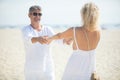 senior couple on beach holding outstretched hands Royalty Free Stock Photo