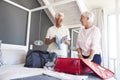 Senior Couple In Bedroom Packing Suitcase For Vacation Royalty Free Stock Photo