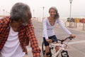 Senior couple with bicycle looking each other on promenade Royalty Free Stock Photo