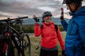 Senior couple bikers high fiving outdoors in forest in autumn day.