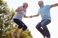 Senior Couple Bouncing On Trampoline In Garden Royalty Free Stock Photo