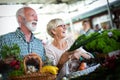 Senior couple buying fresh vegetables and fruits at the local market