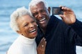 Senior Couple With Camera On Beach Royalty Free Stock Photo