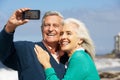 Senior Couple With Camera On Beach Royalty Free Stock Photo