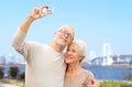 Senior couple with camera over rainbow bridge Royalty Free Stock Photo