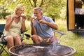 Senior Couple Camping In Countryside With RV Toasting And Eating Marshmallows Outdoors On Fire Royalty Free Stock Photo