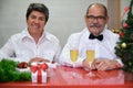 Senior couple celebrating christmas with champagne looking at camera. Royalty Free Stock Photo