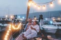 Senior couple cheering with champagne and eating watermelon on boat - Old people having fun together drinking and laughing -