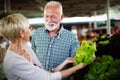 Senior family couple choosing bio food fruit and vegetable on the market during weekly shopping Royalty Free Stock Photo