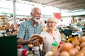 Senior family couple choosing bio food fruit and vegetable on the market during weekly shopping Royalty Free Stock Photo