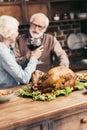 senior couple clinking glasses on thanksgiving dinner with turkey Royalty Free Stock Photo