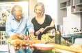 Senior couple cooking healthy food and drinking red wine