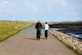 Senior couple cycling alongside the sea