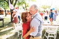 A senior couple dancing on a garden party outside in the backyard.