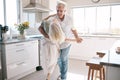 Senior couple dancing, kitchen and happiness with love, care and support in morning at house. Elderly man, old woman and Royalty Free Stock Photo