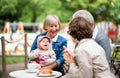 Senior couple with daughter and baby granddaughter sitting outdoors in cafe. Royalty Free Stock Photo