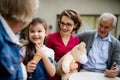 Senior couple with daughter and granddaughter sitting outdoors in cafe, talking. Royalty Free Stock Photo