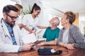 Senior Couple In Discussion With Health Visitor At Home. Royalty Free Stock Photo