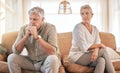 Senior couple, divorce and disagreement in conflict, fight or argument on living room sofa at home. Elderly woman and