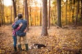 Senior couple with dog on a walk in an autumn forest. Royalty Free Stock Photo